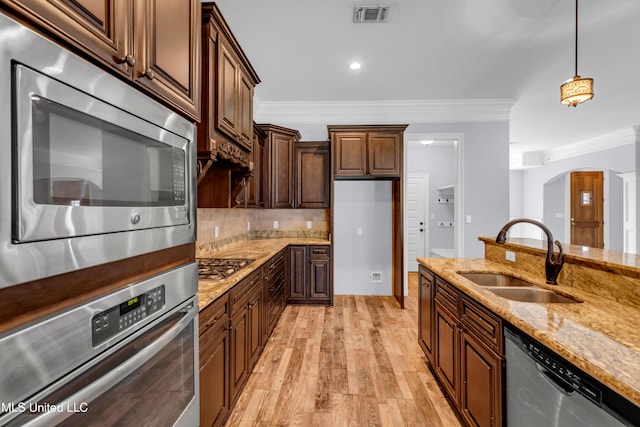 709 Champagne Dr, Biloxi, MS 39532 - kitchen featuring stainless steel appliances, arched walkways, light wood-style floors, ornamental molding, and light stone counters