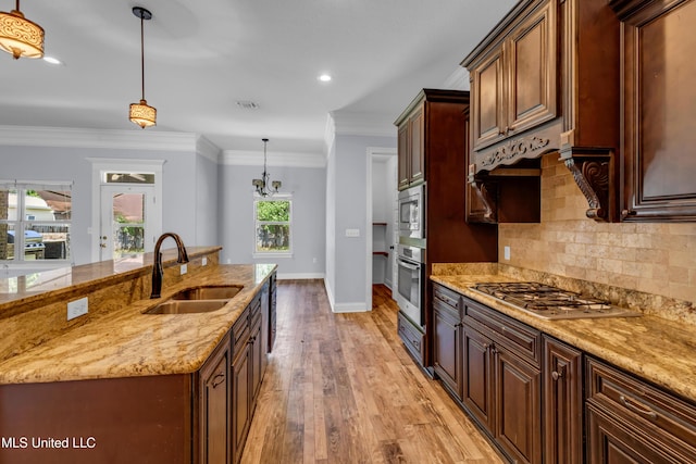 709 Champagne Dr, Biloxi, MS 39532 - kitchen featuring stainless steel appliances, light wood finished floors, hanging light fixtures, backsplash, and light stone counters