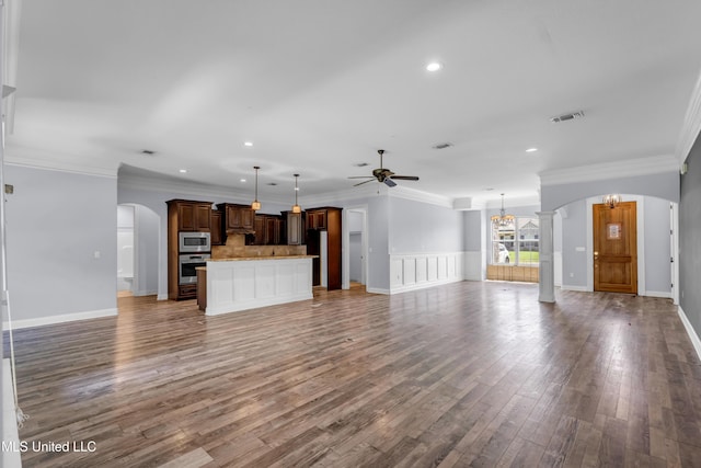 709 Champagne Dr, Biloxi, MS 39532 - unfurnished living room with arched walkways, ceiling fan, a chandelier, wood finished floors, and recessed lighting