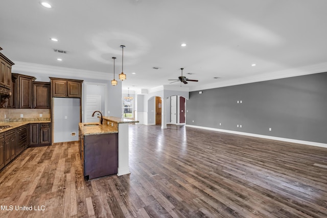 709 Champagne Dr, Biloxi, MS 39532 - kitchen featuring arched walkways, ceiling fan, open floor plan, recessed lighting, and crown molding