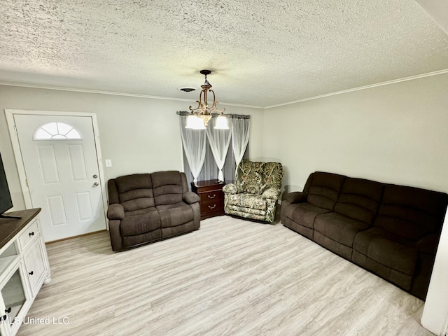 living area featuring light wood-style floors, a chandelier, ornamental molding, and a textured ceiling