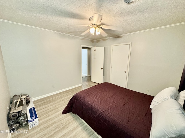 bedroom featuring a textured ceiling, ceiling fan, light wood-style flooring, baseboards, and crown molding