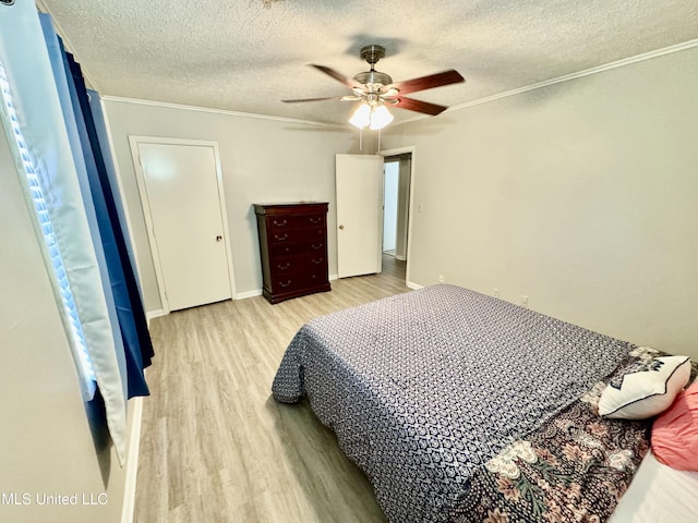 bedroom with a textured ceiling, wood finished floors, a ceiling fan, baseboards, and ornamental molding