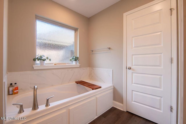 full bath with a bath and wood finished floors