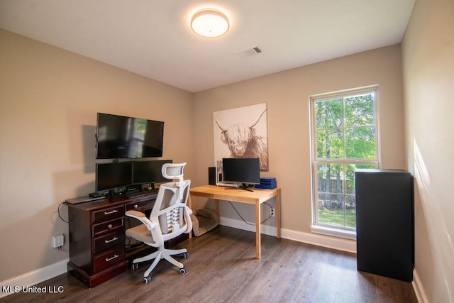 office space with baseboards, visible vents, and wood finished floors