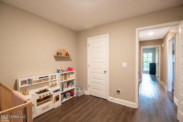 rec room with baseboards and dark wood-style flooring