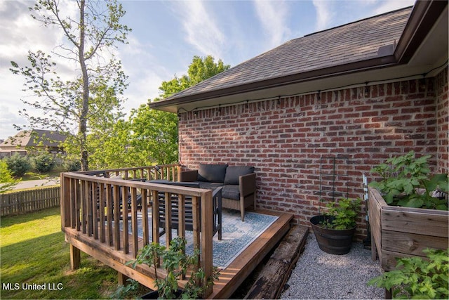 wooden terrace featuring fence, a yard, and outdoor lounge area