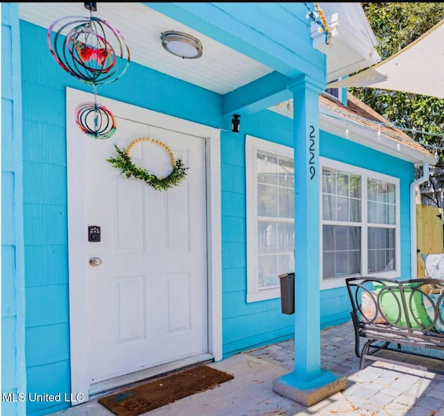 view of exterior entry with covered porch