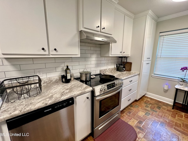kitchen featuring appliances with stainless steel finishes, under cabinet range hood, ornamental molding, baseboards, and decorative backsplash