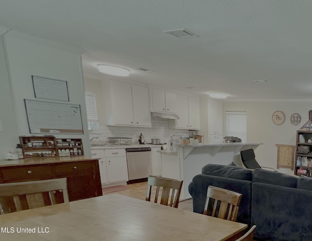 kitchen with dishwasher, crown molding, decorative backsplash, white cabinetry, and under cabinet range hood