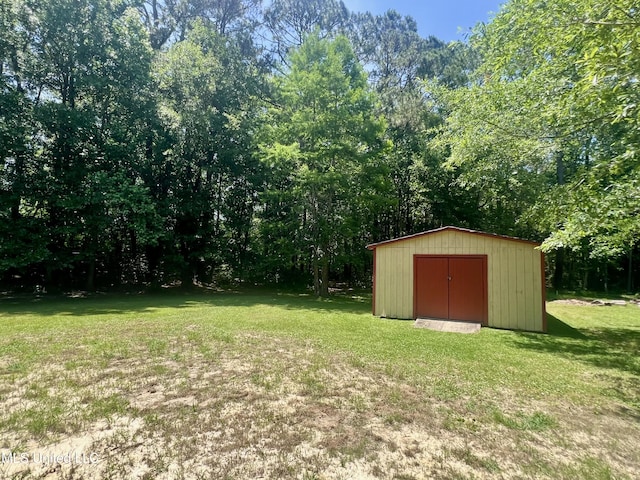 view of green lawn with a storage shed and an outbuilding