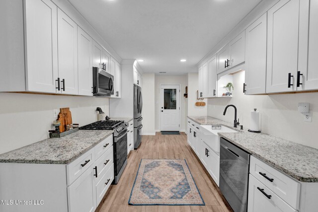 6177 W Sandbourne, Olive Branch, MS 38654 - kitchen featuring appliances with stainless steel finishes, a sink, light wood-style flooring, recessed lighting, and white cabinetry