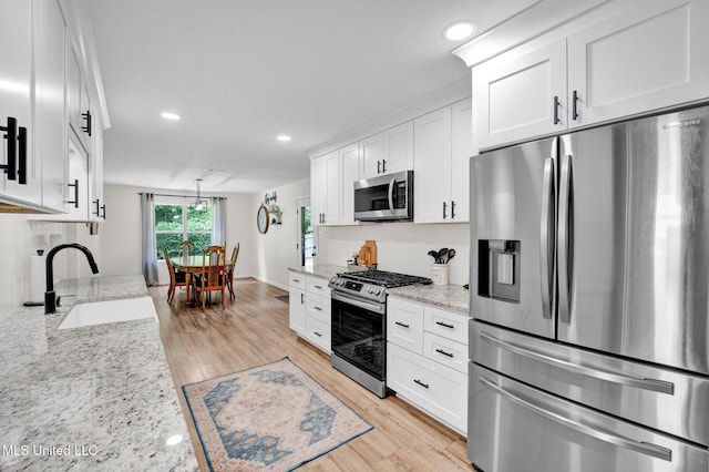 6177 W Sandbourne, Olive Branch, MS 38654 - kitchen with a sink, appliances with stainless steel finishes, white cabinets, and light wood-style flooring