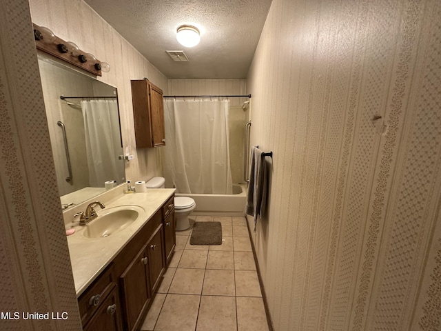 full bathroom featuring shower / bath combination with curtain, vanity, a textured ceiling, tile patterned flooring, and toilet