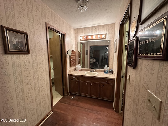 bathroom featuring vanity, hardwood / wood-style floors, and a textured ceiling