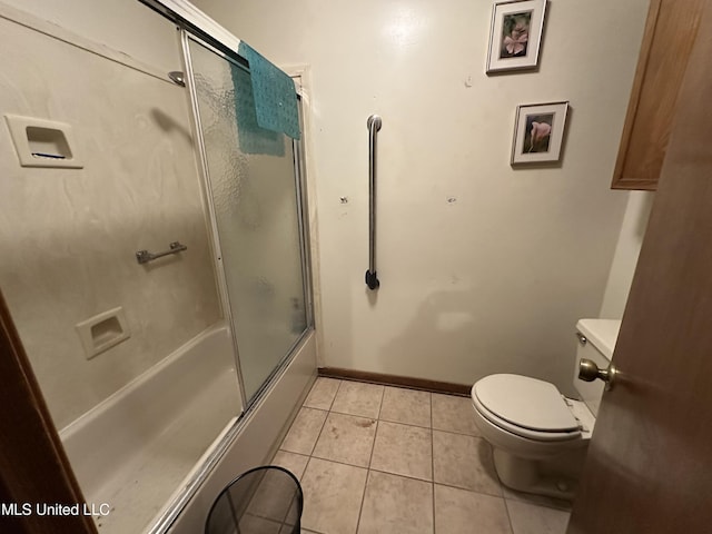 bathroom with tile patterned flooring, toilet, and bath / shower combo with glass door