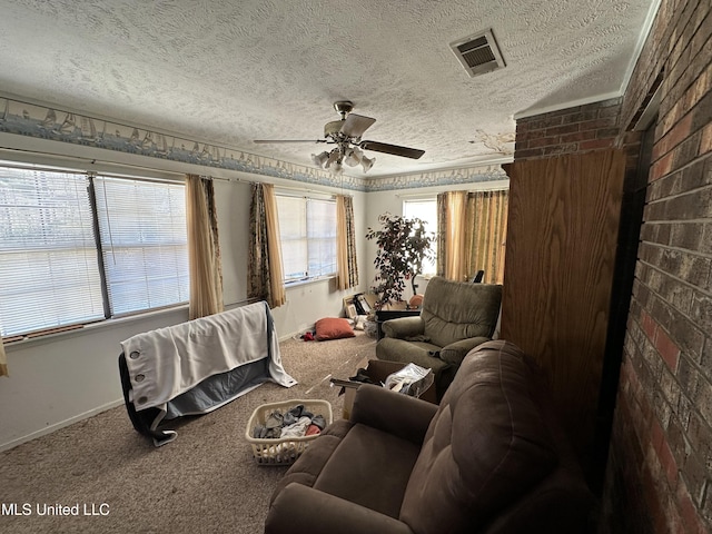 carpeted living room featuring ceiling fan, a textured ceiling, and brick wall