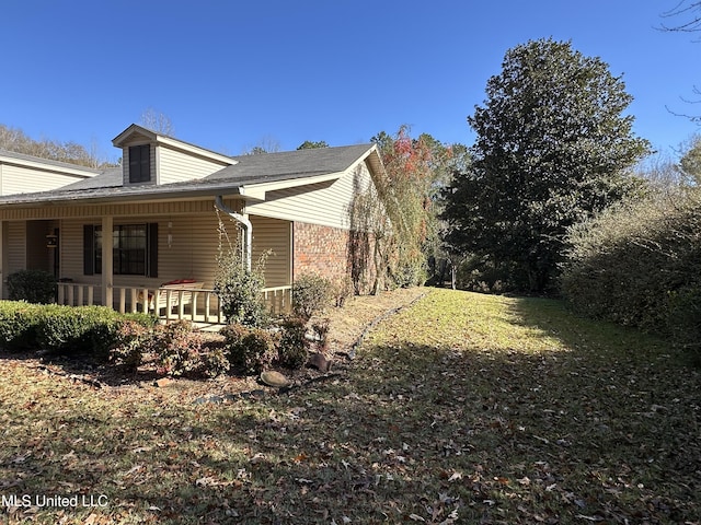 view of home's exterior with a yard and a porch