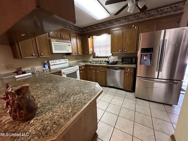 kitchen featuring ceiling fan, sink, kitchen peninsula, light tile patterned floors, and appliances with stainless steel finishes