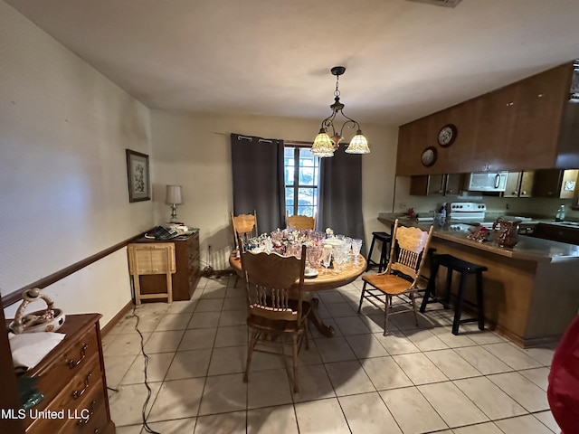 tiled dining room featuring an inviting chandelier