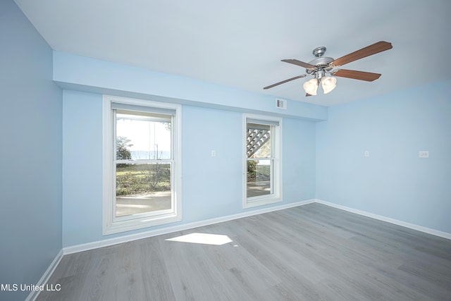 empty room featuring visible vents, baseboards, ceiling fan, and wood finished floors