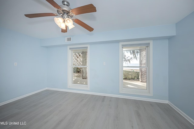 spare room with a ceiling fan, baseboards, visible vents, and wood finished floors