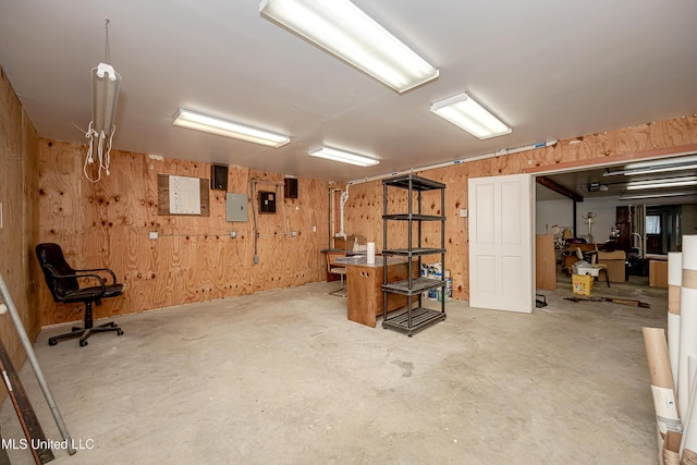 basement featuring electric panel and wooden walls