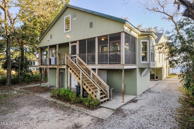 rear view of house featuring a sunroom and stairway