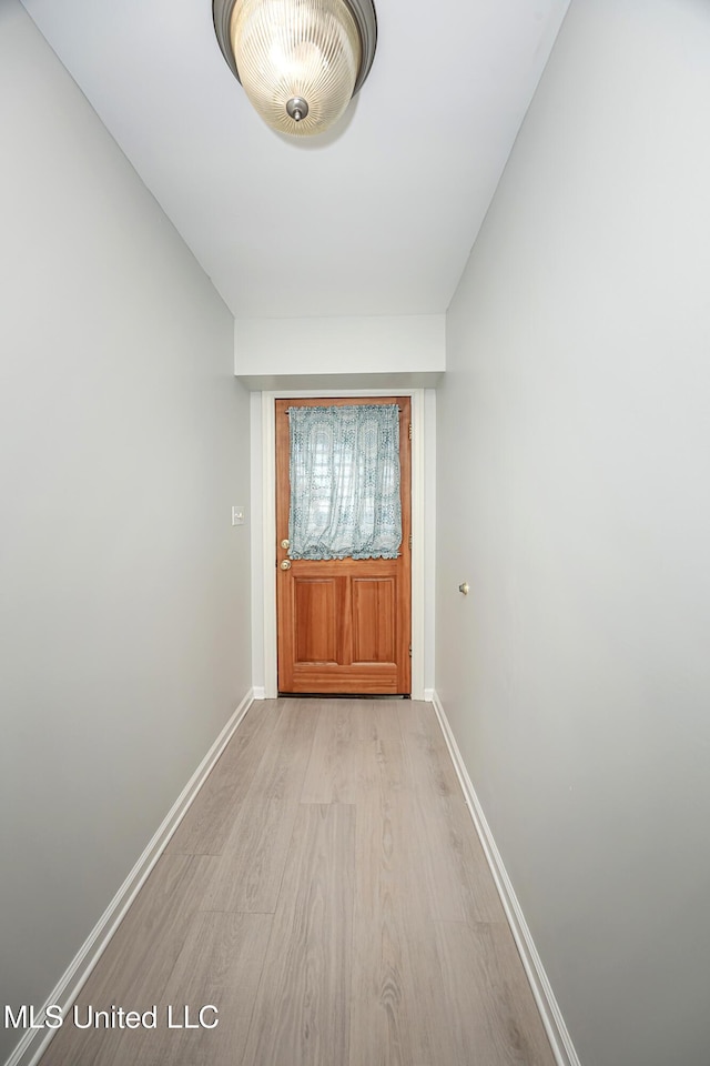 doorway with light wood-style flooring and baseboards