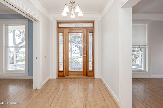 foyer entrance featuring a healthy amount of sunlight, light wood-style flooring, and crown molding