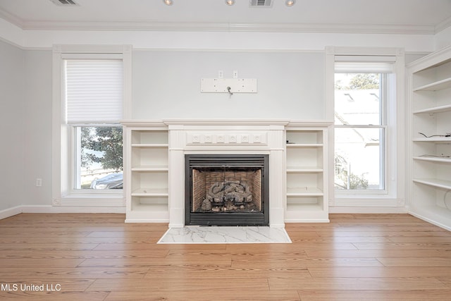 unfurnished living room with wood finished floors, a fireplace with flush hearth, and crown molding