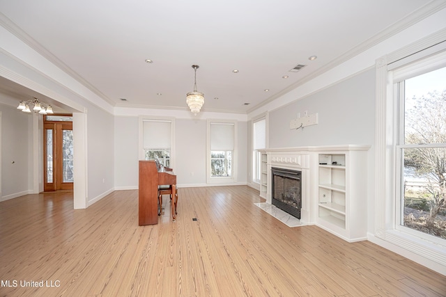 living room with light wood-type flooring, visible vents, and ornamental molding