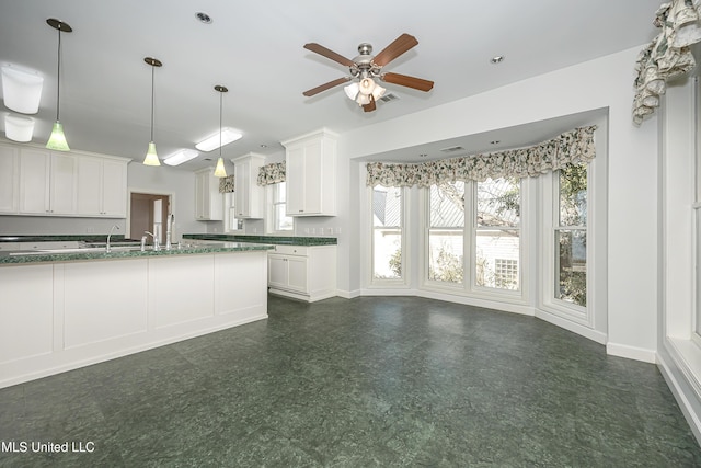 kitchen with baseboards, dark floors, hanging light fixtures, and white cabinets