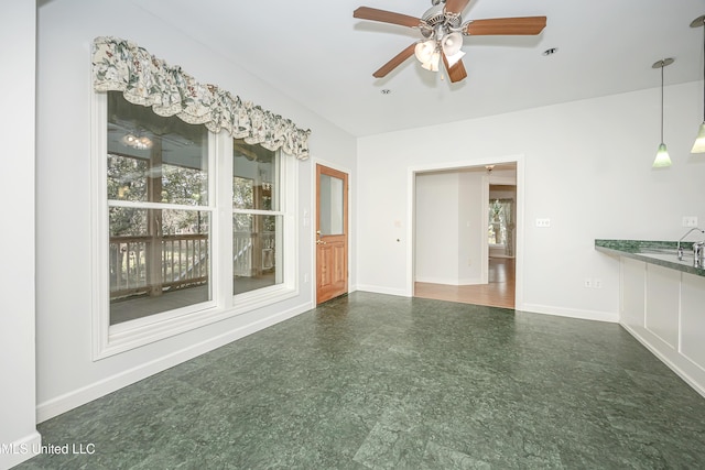 interior space with ceiling fan, baseboards, and tile patterned floors