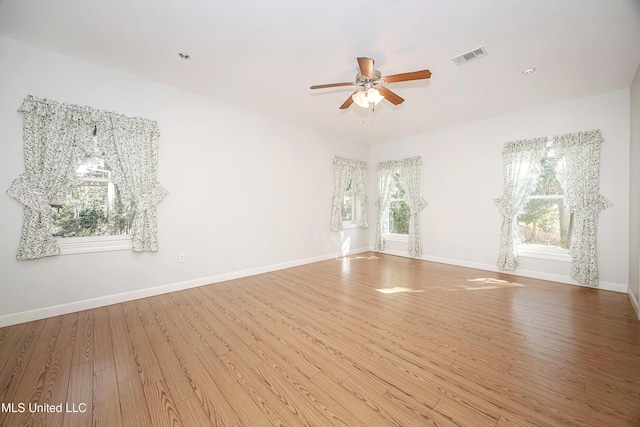 empty room with visible vents, baseboards, and wood finished floors