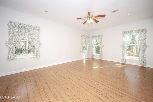 unfurnished room with visible vents, ceiling fan, baseboards, and wood finished floors