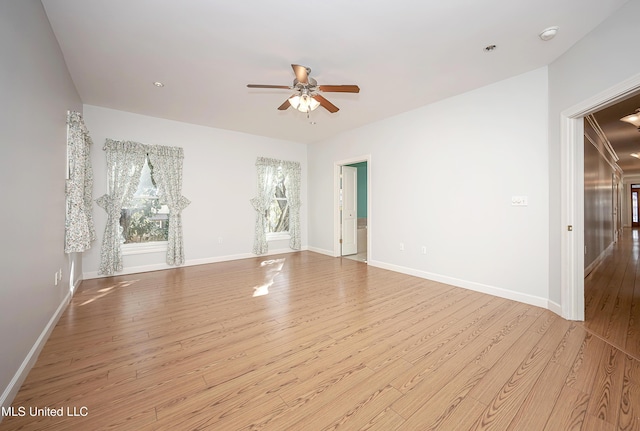 spare room with a ceiling fan, baseboards, and wood finished floors