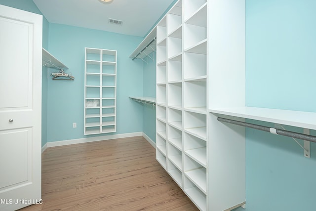 spacious closet featuring visible vents and wood finished floors