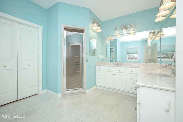 full bath with a shower stall, baseboards, tile patterned flooring, and vanity