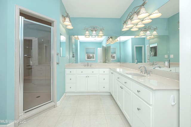 full bath featuring double vanity, a stall shower, tile patterned flooring, and a sink