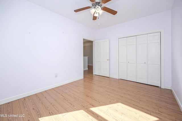 unfurnished bedroom with light wood finished floors, ceiling fan, baseboards, and a closet