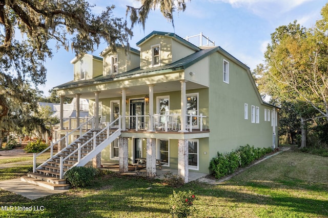 view of front facade featuring a patio, stairway, metal roof, covered porch, and a front yard