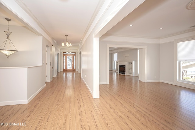 hall with crown molding, light wood finished floors, and an inviting chandelier