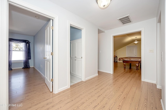 corridor with light wood-style floors, baseboards, and visible vents