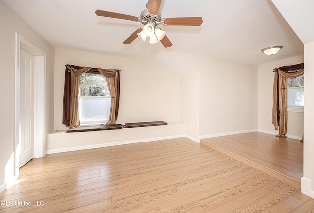 spare room with baseboards and wood finished floors