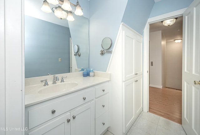 bathroom featuring tile patterned flooring, vanity, and a notable chandelier