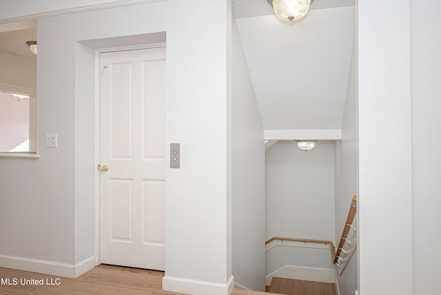 staircase with wood finished floors and baseboards