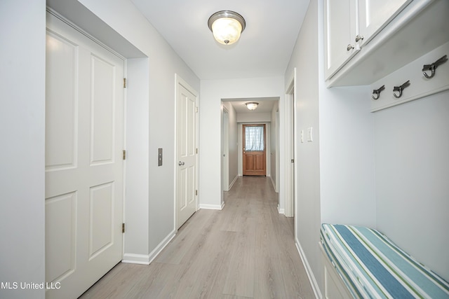 hallway with light wood finished floors and baseboards