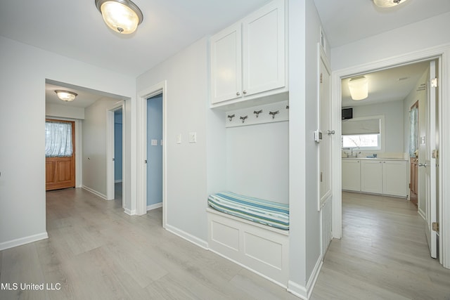 mudroom with baseboards and light wood-style floors