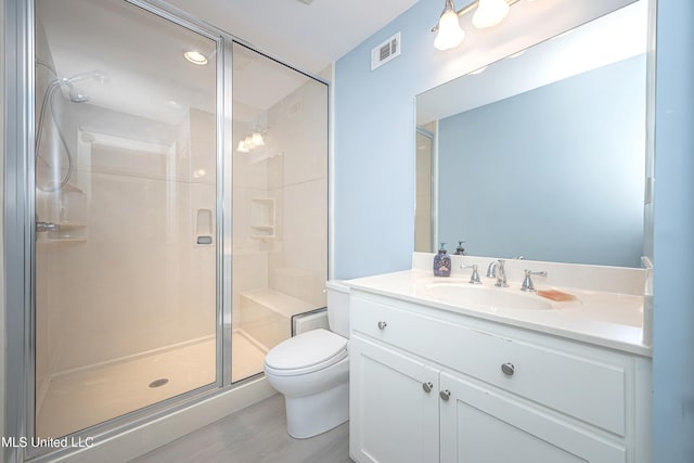 bathroom featuring toilet, a shower stall, visible vents, and vanity